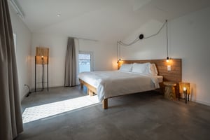 Zimmer „Bagliore“ in der Villa Patria mit Doppelbett, Holzmöbeln und Blick auf den Luganer See.