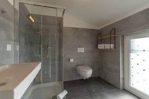Das Badezimmer des Zimmers „Bagliore“ in der Villa Patria mit Dusche, Handtüchern und moderner Ausstattung.