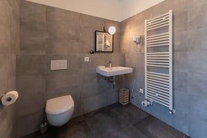 Zimmer „Essenza“ in der Villa Patria mit Doppelbett, Holzmöbeln und Blick auf den Luganer See