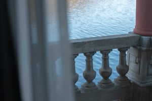 Zimmer „Essenza“ in der Villa Patria mit Doppelbett, Holzmöbeln und Blick auf den Luganer See