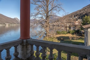 Zimmer „Essenza“ in der Villa Patria mit Doppelbett, Holzmöbeln und Blick auf den Luganer See