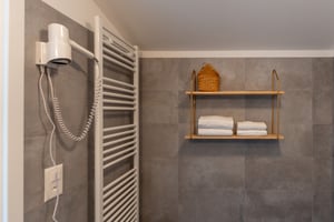 Zimmer „Riflesso“ in der Villa Patria mit Doppelbett, Holzmöbeln und Blick auf den Luganer See