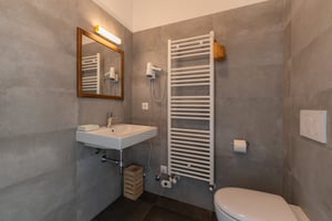 Zimmer „Rugiada“ in der Villa Patria mit Doppelbett, Holzmöbeln und Blick auf den Luganer See