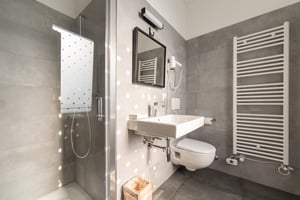 Camera Brezza di Villa Patria con letto matrimoniale, arredi in legno e vista sul Lago di Lugano