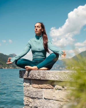 Ragazza pratica meditazione e yoga con vista sul Lago di Lugano